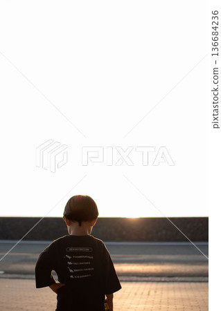boy staring at the sunset boy staring at the sunset 136684236