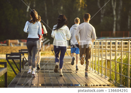 Running group of young athletes jogging marathon in park, healthy outdoor workout Running group of young athletes jogging marathon in park, healthy outdoor workout 136684291