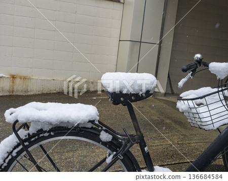 Snow piled high on the saddle, bicycle on a snowy day 136684584