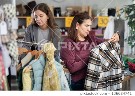 Adult and young woman buying clothes in store Adult and young woman buying clothes in store 136684741
