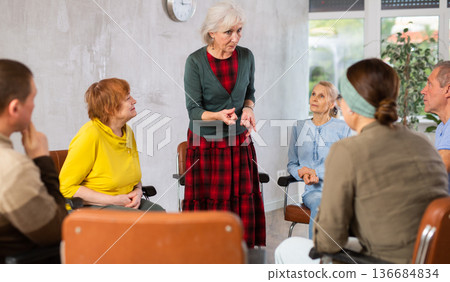 Senior female tutor leading educational class for elderly Senior female tutor leading educational class for elderly 136684834