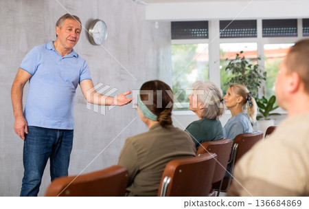 Elderly tutor giving lecture to group of seniors during educational program Elderly tutor giving lecture to group of seniors during educational program 136684869