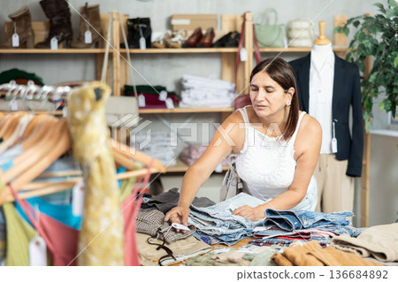 Woman view assortment in clothing department, buying lady trousers Woman view assortment in clothing department, buying lady trousers 136684892