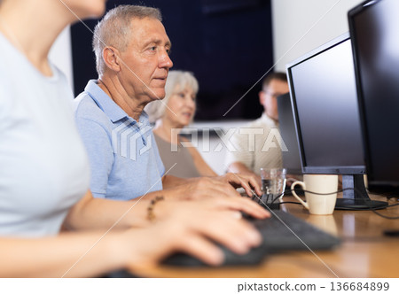 Elderly man studying at computer course in group Elderly man studying at computer course in group 136684899