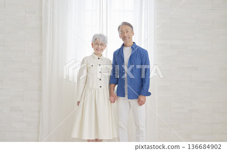 一對老年夫婦在客廳看著鏡頭，這是他們的肖像照。 136684902