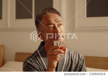 一位老年男子在臥室裡喝威士忌 136684928