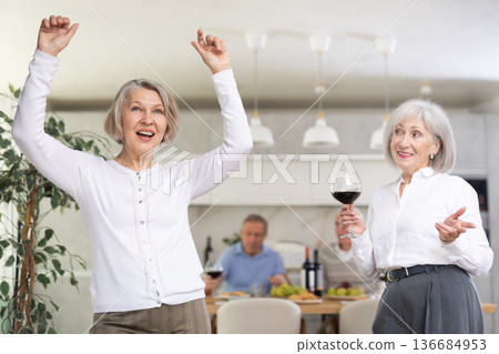 Elderly woman dancing in kitchen with friends Elderly woman dancing in kitchen with friends 136684953