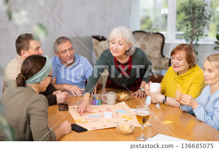 Group of positive older people playing tabletop game Group of positive older people playing tabletop game 136685075