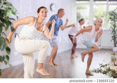 Young woman with senior visitor actively moves and learns to dance balboa Young woman with senior visitor actively moves and learns to dance balboa 136685120