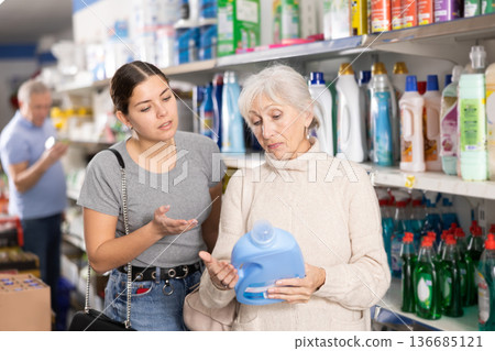 Woman purchasers choosing liquid detergent in big supermarket Woman purchasers choosing liquid detergent in big supermarket 136685121