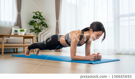 一位女士在家中客廳進行平板支撐訓練 136685693