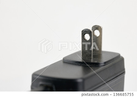 Macro shot of a black AC power adapter with two-prong Type A plug on a white background Macro shot of a black AC power adapter with two-prong Type A plug on a white background 136685755