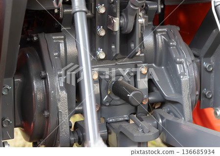 Rear end of farm tractor showing the PTO shaft with cover is used to connect agricultural implements. 136685934