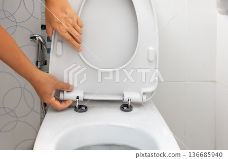 Worker replace hinge rubber plug and Screws for Toilet Seat 136685940