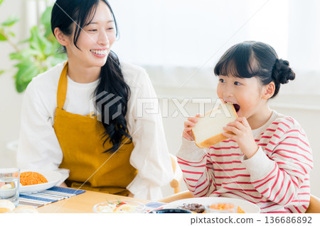 Parent and child eating at the dining room Parent and child eating at the dining room 136686892