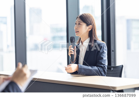 一個女人和一個麥克風說話 136687099