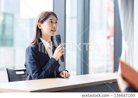 一個女人和一個麥克風說話 136687100