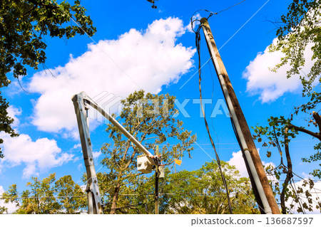 Workers fix power lines after hurricane under blue sky in residential area 136687597
