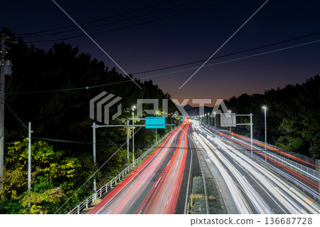 Light trails of cars running on a late-night road Light trails of cars running on a late-night road 136687728