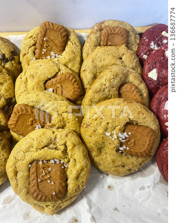 Freshly baked cookies with a golden-brown finish and chocolate chips. Perfectly crisp on the edges with a soft center, offering a delicious, comforting treat for any occasion. 136687774