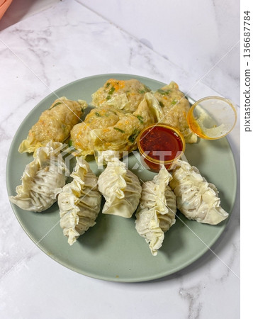 Korean dumplings filled with a mix of savory ingredients like ground meat, tofu, and vegetables. Mandu can be steamed, boiled, or pan-fried, making it a versatile and delicious snack or meal. Korean dumplings filled with a mix of savory ingredients like ground meat, tofu, and vegetables. Mandu can be steamed, boiled, or pan-fried, making it a versatile and delicious snack or meal. 136687784