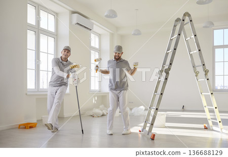 Professional painters with rollers and ladder in bright room interior renovation Professional painters with rollers and ladder in bright room interior renovation 136688129