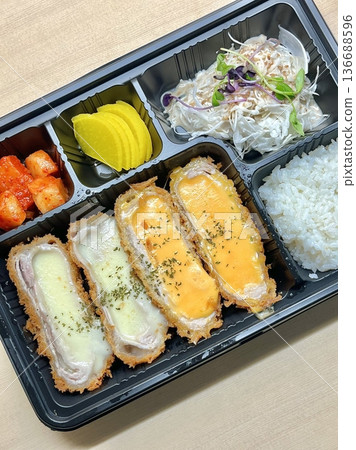 Crispy tonkatsu, a Japanese-style breaded and deep-fried pork cutlet, served with shredded cabbage and drizzled with savory sauce. A delightful balance of crunchy texture and juicy meat. 136688596