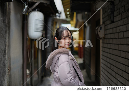 年輕女子走在東京復古購物區的一條小巷裡 年輕女子走在東京復古購物區的一條小巷裡 136688810