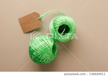 Two green spools of recycled polyester fiber with blank label indicating the product's eco-friendliness. Recycling, conscious waste management Two green spools of recycled polyester fiber with blank label indicating the product's eco-friendliness. Recycling, conscious waste management 136689911