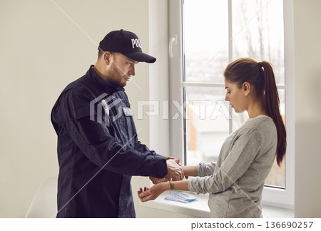 Policeman Arresting Woman And Placing Handcuffs Policeman Arresting Woman And Placing Handcuffs 136690257