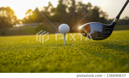 Golf clubs and balls on a green lawn in a beautiful golf course with morning sunshine. Golf clubs and balls on a green lawn in a beautiful golf course with morning sunshine. 136690637