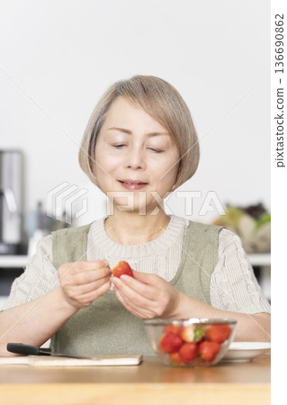 Cut strawberries in the dining kitchen and make a yogurt dessert. 136690862