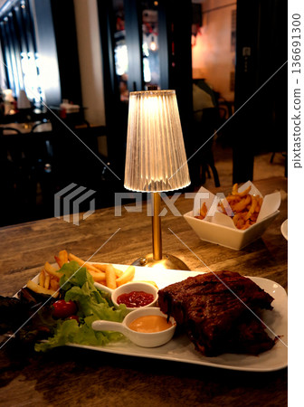 rib barbecue and lamp in dark restaurant room 136691300