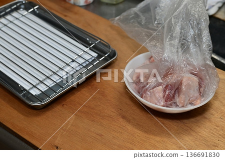Preparation scene: Chicken being seasoned in a plastic bag 136691830