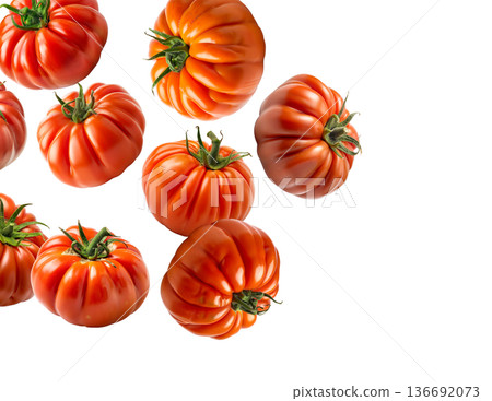 Multiple ripe heirloom tomatoes with ridged textures scattered and on a white background, natural food and healthy eating concept 136692073