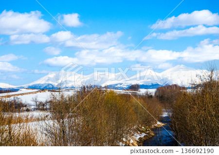 冬日晴空萬裡，北海道美瑛市沖串川和十勝山脈的景色 136692190