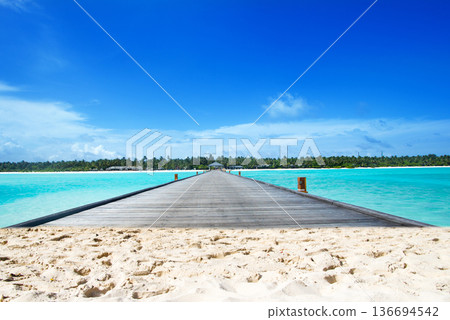 Beautiful beach. Tropical beach. Holiday and vacation concept. Sand, blue sea water, turquoise ocean, sun sky white clouds 136694542