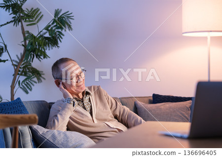 Senior man watching TV in the living room Senior man watching TV in the living room 136696405