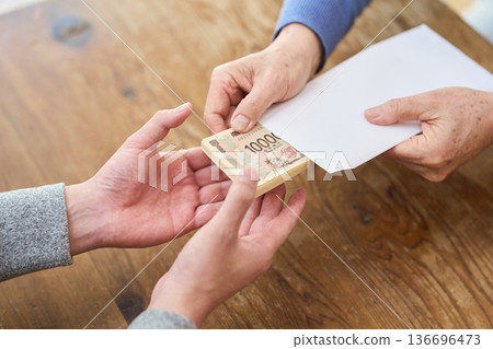 Hands of an Asian man handing over money 136696473