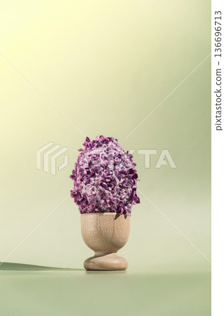 Easter egg made of lilac spring flowers in pastel green background. Sustainable holiday minimalistic still life composition. Copy space template for invitation greeting card 136696713