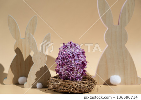 Creative Easter egg shape made of lilac spring petals flowers. Eco-friendly wooden bunnies decoration. Minimal holiday concept still life. Copy space greeting card 136696714