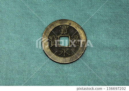 一枚古老的寬榮通寶錢幣放在日本紙上 一枚古老的寬榮通寶錢幣放在日本紙上 136697202