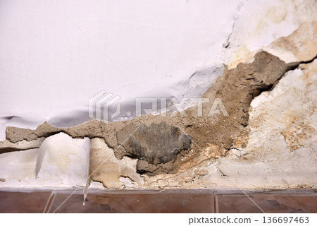 Severe water damage and mold growth on a bathroom ceiling and wall 136697463