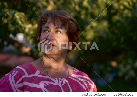 happy senior woman in a pink dress during sunset golden hour 136698102