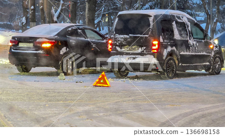 Accident on a winter road Two cars collided on a slippery road. Warning triangle at the scene of a road accident in winter Accident on a winter road Two cars collided on a slippery road. Warning triangle at the scene of a road accident in winter 136698158