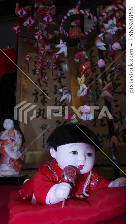 Checkered dolls with hanging decorations in the background Checkered dolls with hanging decorations in the background 136698858
