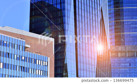 Modern sustainable glass office buildings. Exterior view of corporate headquarters glass buildings architecture.Glass windows in energy-efficient buildings. Financial business center buildings. Modern sustainable glass office buildings. Exterior view of corporate headquarters glass buildings architecture.Glass windows in energy-efficient buildings. Financial business center buildings. 136699475