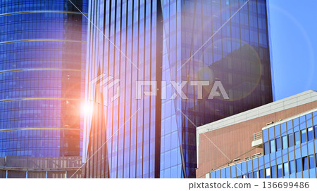 Modern sustainable glass office buildings. Exterior view of corporate headquarters glass buildings architecture.Glass windows in energy-efficient buildings. Financial business center buildings.  136699486