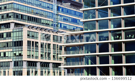 Modern sustainable glass office buildings. Exterior view of corporate headquarters glass buildings architecture.Glass windows in energy-efficient buildings. Financial business center buildings.  136699512