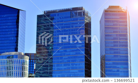 Modern sustainable glass office buildings. Exterior view of corporate headquarters glass buildings architecture.Glass windows in energy-efficient buildings. Financial business center buildings. Modern sustainable glass office buildings. Exterior view of corporate headquarters glass buildings architecture.Glass windows in energy-efficient buildings. Financial business center buildings. 136699521